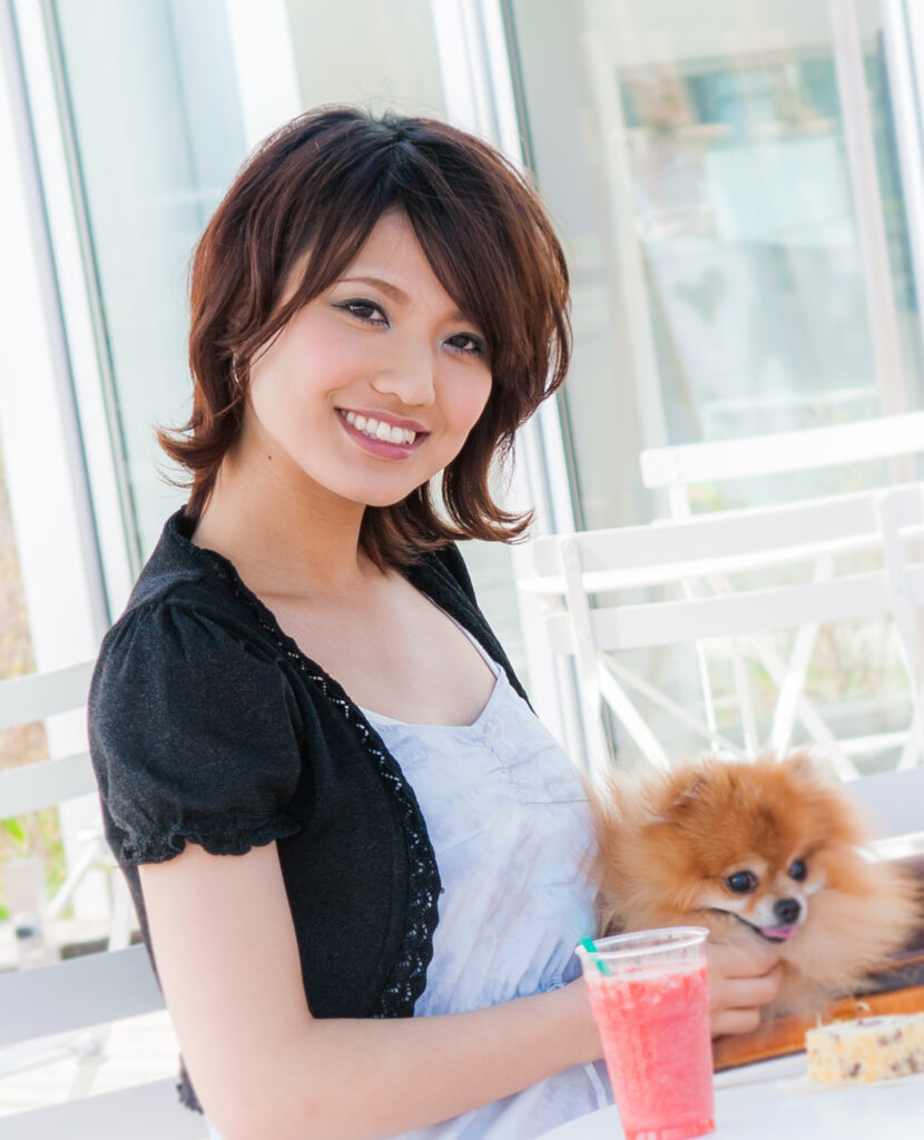 犬とカフェでくつろぐ女性